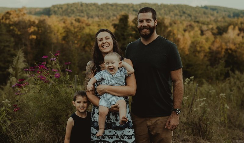 Kayla Searles with her husband and two children outdoors
